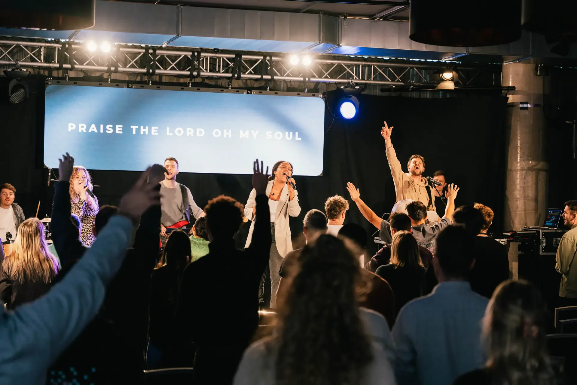 Worship in der Ecclesia Family. Eine Band spielt auf einer Bühne. Das Publikum hebt anbetungsvoll die Arme. Diese Atmosphäre wollen wir auch auf der Ecclesia Conference spürbar machen.